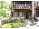 Close-up of a brick townhome featuring a covered balcony and professionally landscaped front yard at 1952 Maritime Way, Atlanta, GA 30318