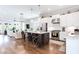 Open-concept kitchen with white cabinets, a dark island, stainless steel appliances, and hardwood flooring at 1952 Maritime Way, Atlanta, GA 30318
