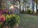 Picturesque backyard with storage shed, lush greenery, and mature trees at 2380 Emerald Dr, Loganville, GA 30052