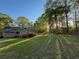 Home exterior with large backyard, lush lawn, and mature trees offering shade at 2380 Emerald Dr, Loganville, GA 30052
