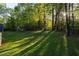Expansive backyard featuring lush green lawn, mature trees, and a storage shed at 2380 Emerald Dr, Loganville, GA 30052