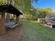 Beautiful backyard featuring a rustic pergola swing, lush lawn, and an outdoor seating area at 2380 Emerald Dr, Loganville, GA 30052