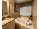 Bathroom with granite counters, tub, and separate tile accents at 2380 Emerald Dr, Loganville, GA 30052