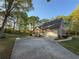 Home exterior with attached garage and long driveway, surrounded by lush greenery at 2380 Emerald Dr, Loganville, GA 30052