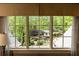Window view of the backyard pool, cabana and mature trees creating an oasis at 5178 S Trimble Rd, Atlanta, GA 30342