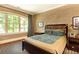 Cozy bedroom with a large window, hardwood floors, and a comfortable bed dressed in patterned bedding at 5178 S Trimble Rd, Atlanta, GA 30342