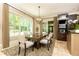 Dining room with many windows looking out at a lush green yard, light stone flooring, and stylish chandelier at 5178 S Trimble Rd, Atlanta, GA 30342