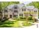 Inviting traditional home featuring a stone facade, manicured lawn, and lush landscaping at 5178 S Trimble Rd, Atlanta, GA 30342