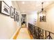 Hallway with hardwood floors, gallery wall, and modern lighting fixture at 5178 S Trimble Rd, Atlanta, GA 30342