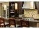 Close-up view of a kitchen featuring mosaic tile backsplash, stainless steel appliances, and a breakfast bar at 5178 S Trimble Rd, Atlanta, GA 30342