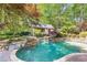 Beautiful backyard pool with rock waterfall, lush landscaping, and a pool house at 5178 S Trimble Rd, Atlanta, GA 30342