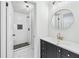 Modern bathroom with walk-in shower, black vanity, and round mirror at 5180 Stone Trce, Stone Mountain, GA 30083