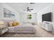 Bright main bedroom featuring a ceiling fan, large window, and neutral decor at 5180 Stone Trce, Stone Mountain, GA 30083