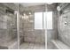 A glass shower shows neutral tiled walls and a window at 127 Pebblebrook Way, Temple, GA 30179