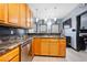 Well-lit kitchen with wooden cabinets, updated appliances, and granite counters at 127 Pebblebrook Way, Temple, GA 30179