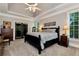 Relaxing bedroom featuring a large bed, tray ceiling, and access to the outdoors through double doors at 1485 Mill Place Dr, Dacula, GA 30019