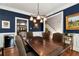 Stylish dining room with navy walls, hardwood floors, and a glimpse into the adjacent rooms for seamless entertaining at 1485 Mill Place Dr, Dacula, GA 30019