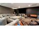Living room in finished basement features a gray sectional and large TV at 1485 Mill Place Dr, Dacula, GA 30019