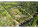 Aerial view showcasing a 5+ acre lot surrounded by lush greenery and mature trees at 1660 Maple Ridge Dr, Loganville, GA 30052