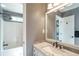 Well-lit bathroom featuring single sink vanity with marble countertop and shower/tub combo at 1660 Maple Ridge Dr, Loganville, GA 30052