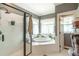 Bathroom featuring a glass-enclosed shower and a relaxing soaking tub by a window at 1660 Maple Ridge Dr, Loganville, GA 30052