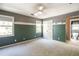 Empty bedroom with green accent walls, windows, neutral carpet, and double closet at 1660 Maple Ridge Dr, Loganville, GA 30052