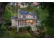Charming two-story home boasts a welcoming porch, red shutters, and lush landscaping for a picturesque setting at 1660 Maple Ridge Dr, Loganville, GA 30052