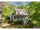 Charming two-story home features a welcoming porch, red shutters, and lush landscaping at 1660 Maple Ridge Dr, Loganville, GA 30052