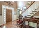 Inviting foyer with a wooden front door with glass detailing, hardwood floors, and a staircase with white railings at 1660 Maple Ridge Dr, Loganville, GA 30052