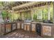 Outdoor kitchen under a pergola with grill and counter space, great for entertaining at 1660 Maple Ridge Dr, Loganville, GA 30052