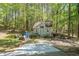 Backyard storage shed surrounded by trees, with lawn equipment nearby at 1660 Maple Ridge Dr, Loganville, GA 30052