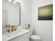 Powder room with a modern vanity, mirror, white marble countertop and gold hardware at 1882 Francis Nw Ave, Atlanta, GA 30318