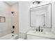 Bathroom with a modern vanity, framed mirror, and tiled shower with recessed shelf at 1882 Francis Nw Ave, Atlanta, GA 30318