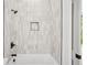 Tiled shower with a built-in shelf and black hardware in modern bathroom at 1882 Francis Nw Ave, Atlanta, GA 30318