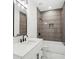 Modern bathroom featuring a marble countertop, framed mirror, and gray-tiled shower with built-in niche at 1882 Francis Nw Ave, Atlanta, GA 30318