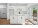 A beautifully designed, modern white kitchen with stainless steel appliances, quartz countertops, and a kitchen island at 1882 Francis Nw Ave, Atlanta, GA 30318