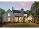 Expansive backyard showcasing the home's architecture, screened porch, outdoor dining area, and lush landscaping at 284 Hook St, Alpharetta, GA 30009