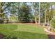 Lush backyard features a well-maintained lawn, mature trees, and a secluded seating area at 284 Hook St, Alpharetta, GA 30009