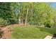 Lush backyard features a well-maintained lawn, mature trees, and a secluded seating area at 284 Hook St, Alpharetta, GA 30009