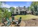 Backyard with a fire pit surrounded by chairs, lush lawn, and view of the house at 284 Hook St, Alpharetta, GA 30009
