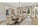 Stylish dining room boasts a modern chandelier, neutral decor, a large table with seating and views into other rooms at 284 Hook St, Alpharetta, GA 30009