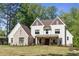 Beautiful home exterior with manicured lawn, white siding, brick accents, and rocking chairs on a covered front porch at 284 Hook St, Alpharetta, GA 30009