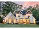 Charming exterior featuring a well-manicured lawn, white siding, brick accents and a cozy front porch with rocking chairs at 284 Hook St, Alpharetta, GA 30009