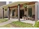 Inviting front porch with brick flooring, rocking chairs, wooden pillars, and hanging ferns creates a warm welcome at 284 Hook St, Alpharetta, GA 30009