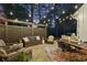 Cozy outdoor patio area featuring a stone floor, comfortable seating, a dining table, and ambient string lights at 284 Hook St, Alpharetta, GA 30009