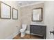 Elegant powder room featuring a stylish vanity with marble countertop, modern fixtures, and unique artwork at 284 Hook St, Alpharetta, GA 30009