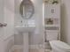 Small half bathroom with pedestal sink, tiled walls, and overhead storage at 486 Crestmont Ln, Canton, GA 30114