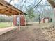 View of two backyard storage sheds with one sheltered by a carport-style structure at 133 Dailey Mill Rd, Mcdonough, GA 30253