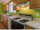 A kitchen with wooden cabinets, white appliances, and view to a breakfast nook with wooden floors at 133 Dailey Mill Rd, Mcdonough, GA 30253