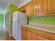 A well-lit kitchen featuring wooden cabinets, light countertops, and a white refrigerator at 133 Dailey Mill Rd, Mcdonough, GA 30253